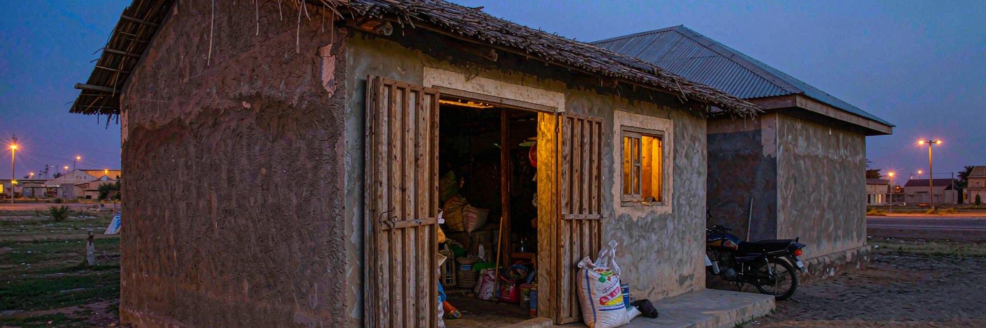 Small East African shop glowing warmly at dusk — AI-generated illustrative scene