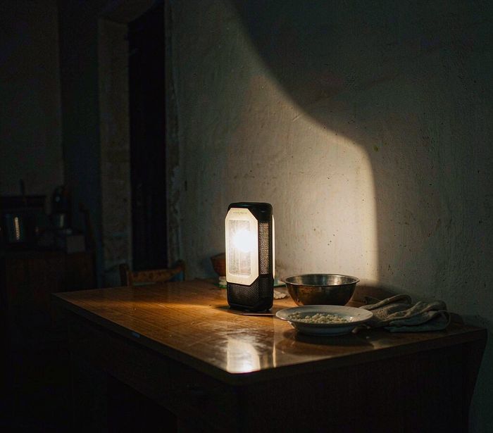 Rechargeable LED lantern lighting a table during a night power outage — AI-generated illustrative scene